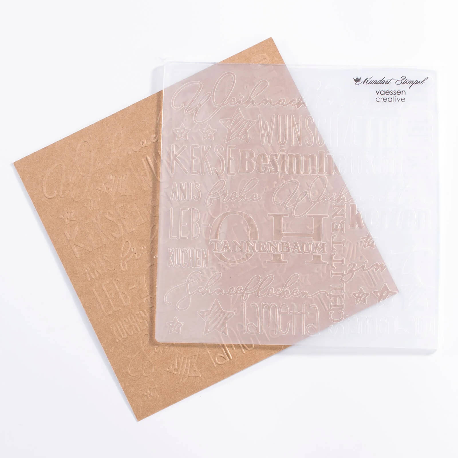 Der Mundart Stempel Prägeschablone "Weihnachten" mit deutschen Urlaubsmotiven ist bereit für Ihre Sizzix BigShot Präge- und Stanzmaschine, abgebildet auf einem braunen Blatt Papier.