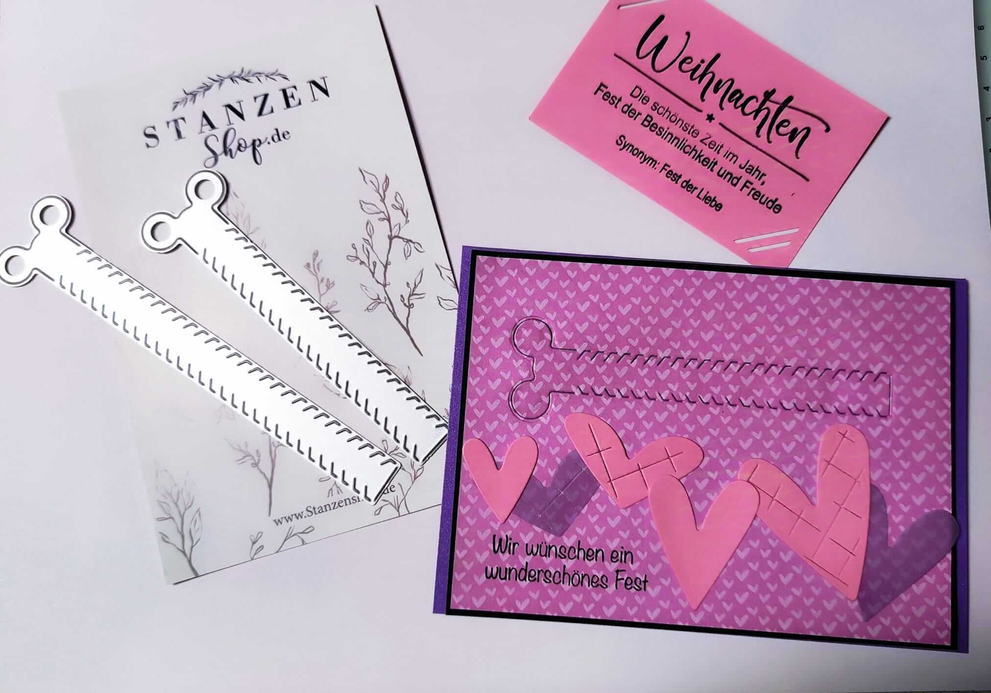 Das Set Stanzschablone Zwei Reißverschlüsse für Gutscheine von Stanzenshop.de enthält zwei Stanzformen, eine rosafarbene Karte mit Herzen und deutschem Text, eine rosafarbene Weihnachtsgrußkarte und einen botanischen Hintergrund - ideal für Bastel-Fans.