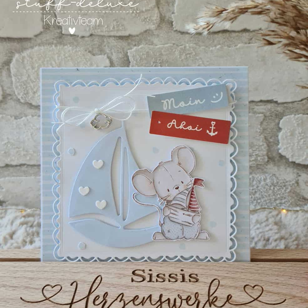 Handgemachte Grußkarte mit Maus, Anker, Segelboot, Herzen und den Texten "Moin" & "Ahoi". Hergestellt mit der Stanzschablone Segelboot mit Mond von Stanzenshop.de, perfekt zum Basteln & Scrapbooking. Abgebildet auf einem Holzständer.