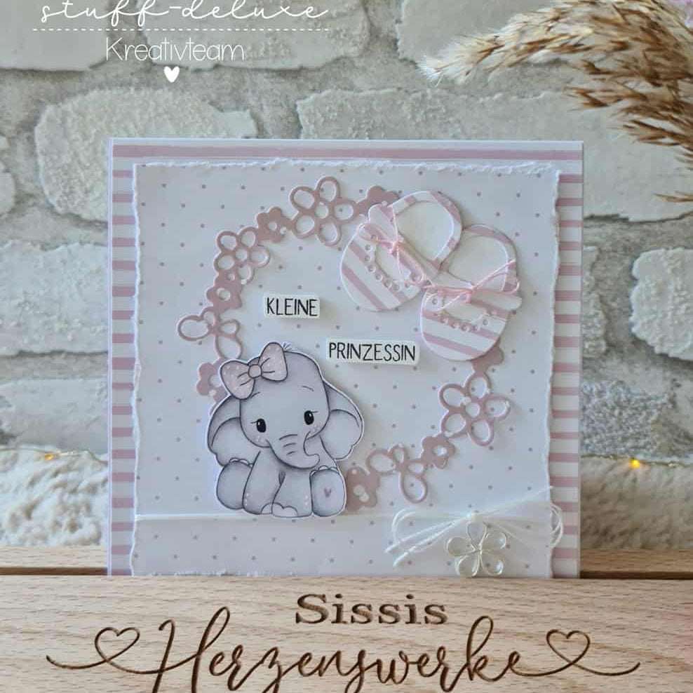 Die "Stanzschablone Babyschuhe im Blütenkranz" von Stanzenshop.de zeigt zarte Babyschuhe im filigranen Blütenkranz und "Kleine Prinzessin" auf pastellfarbenem Hintergrund, wunderschön illustriert und liebevoll gestaltet.