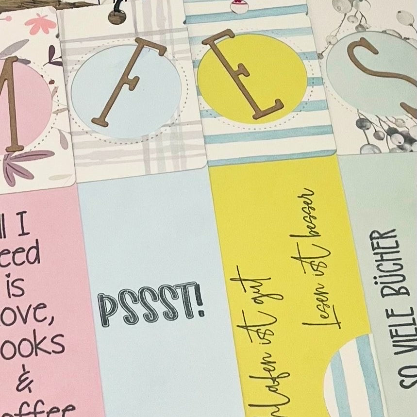 Die Stanzschablone: Klappetikett von Stanzenshop.de bietet farbenfrohe, sich überlappende Lesezeichen mit einzigartigen Designs - perfekt für Scrapbooking oder als Inspiration für Ihre eigenen Etiketten gestalten Projekte.