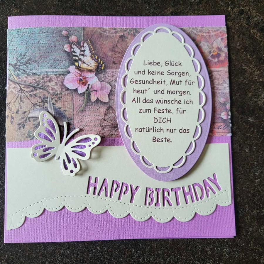 Eine handgefertigte lila und rosa Geburtstagskarte basteln mit einem Schmetterling, floralem Hintergrund, deutscher Geburtstagsnachricht in einem ovalen Rahmen und dem Stanzenshop.de Stanzschablone: Happy Birthday Wimpel Gruß.