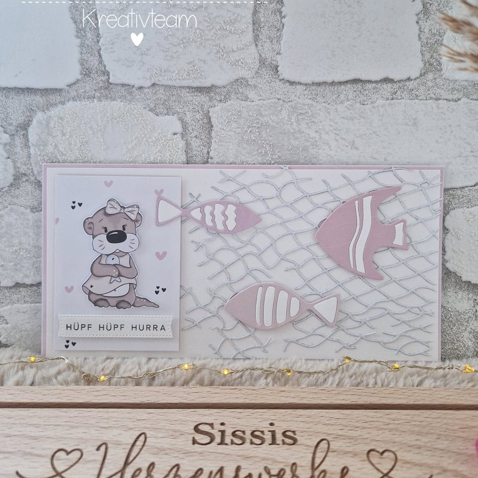 Eine handgefertigte Karte mit Bären- und Fischausschnitten, hergestellt mit der Stanzschablone: Fischernetz von Stanzenshop.de, zeigt "HÜPF HÜPF HURRA" über einem "Sissis Herzenwerke"-Schild - ideal zum Basteln oder Scrapbooking!.