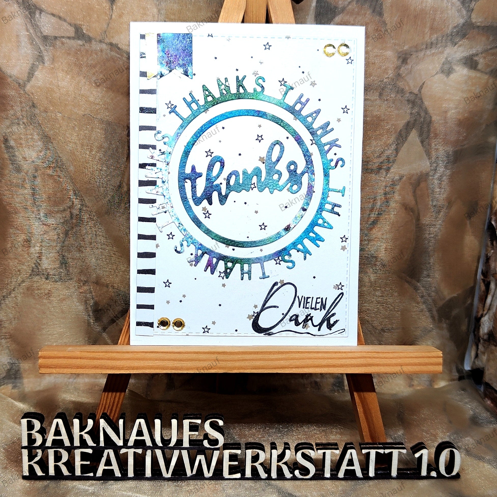 Die handgefertigte Karte verwendet die Stanzenshop.de Stanzschablone: Danke im runden Rahmen, mit "Danke" in einem blauen Kreis mit Akzenten und "Vielen Dank", auf einer Holzstaffelei - ideal für Dankeskarten basteln oder Scrapbooking.