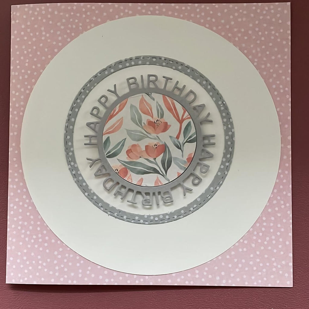Beschreibung: Eine fröhliche Geburtstagskarte mit Polka Dots auf einem rosa Hintergrund, präsentiert von Stanzenshop.de und der Stanzschablone Happy Birthday auf rundem Schriftzug.