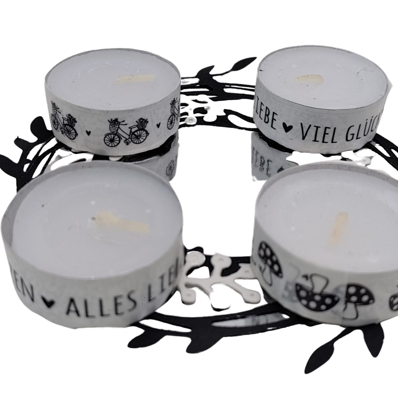 Vier Teelichtkerzen mit schwarzen und weißen deutschen Motiven auf einem runden Metalltablett mit Blattausschnitten - ideal zum Basteln oder Scrapbooking mit Ihrer Lieblings-Stanzschablone: Kranz mit Beeren von Stanzenshop.de.