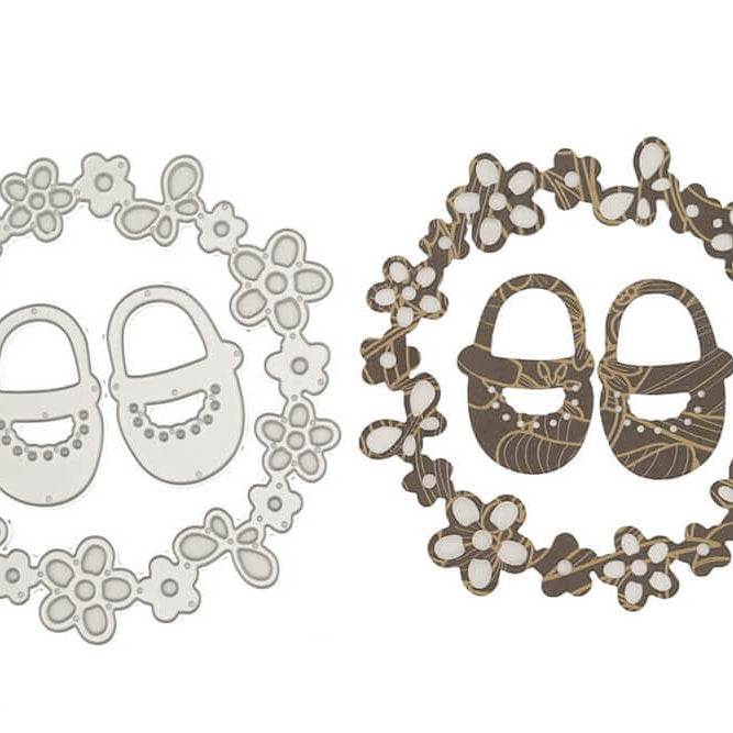 Die Stanzschablone Babyschuhe im Blütenkranz von Stanzenshop.de zeigt zwei kreisrunde Rahmen mit Babyschuhen - einer in Weiß, der andere in Braun mit Goldmuster - ideal für charmante Stanzmotive.