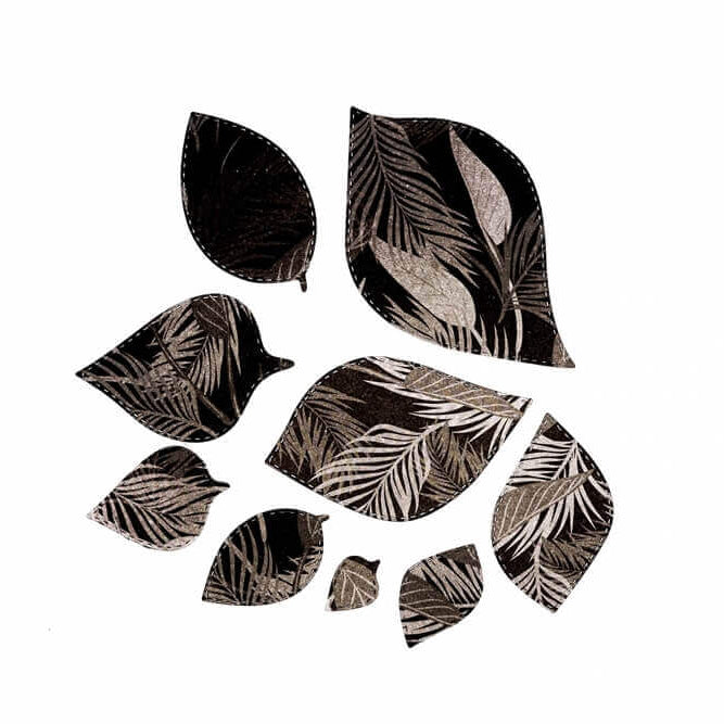 Neun blattförmige Ausschnitte, hergestellt mit der "Stanzschablone: Blätter in verschiedenen Größen" von Stanzenshop.de, zeigen ein monochromes botanisches Muster und sind auf weißem Hintergrund angeordnet - eine Inspiration für Bastelprojekte.