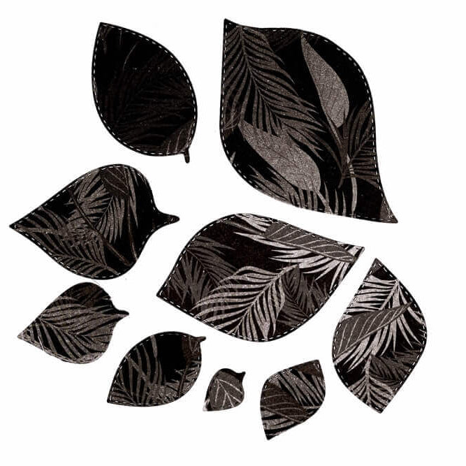 Neun schwarze blattförmige Ausschnitte mit weißen botanischen Mustern werden auf weißem Hintergrund dargestellt - ideal zum Basteln mit der "Stanzschablone: Blätter in verschiedenen Größen" von Stanzenshop.de.