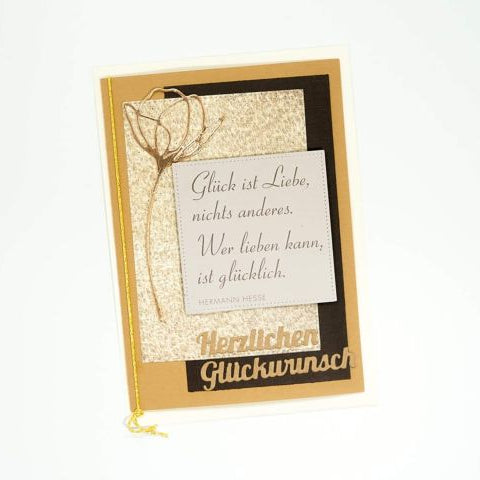 Eine deutsche Grußkarte mit goldenen und beigen Akzenten mit einem Glücks- und Liebeszitat, hergestellt mit der Stanzenschablone Blume mit zwei Blüten von Stanzenshop.de und kompatibel mit Stanze Big Shot. Am unteren Rand steht "Herzlichen Glückwunsch".