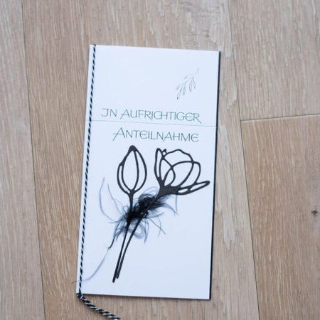 Eine deutsche Kondolenzkarte mit floralem Design, hergestellt mit der Stanzenshop.de Stanzschablone Blume mit zwei Blüten die, ruht auf Holz. Auf der Karte steht "In aufrichtiger Anteilnahme" in grüner Schrift.