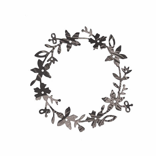 Die Stanzschablone Blumenkranz von Stanzenshop.de ist eine kreisförmige schwarze Metallstanze mit gleichmäßig verteilten Blättern und Blüten, ideal für Bastelprojekte und auf weißem Hintergrund abgebildet.