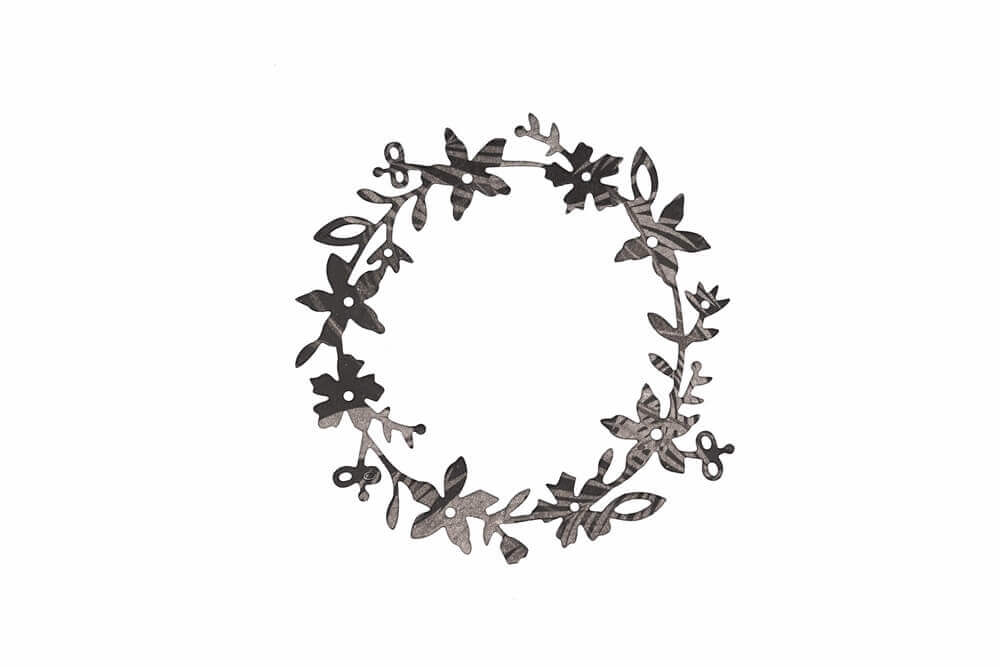 Die Stanzschablone Blumenkranz von Stanzenshop.de ist eine kreisförmige schwarze Metallstanze mit gleichmäßig verteilten Blättern und Blüten, ideal für Bastelprojekte und auf weißem Hintergrund abgebildet.