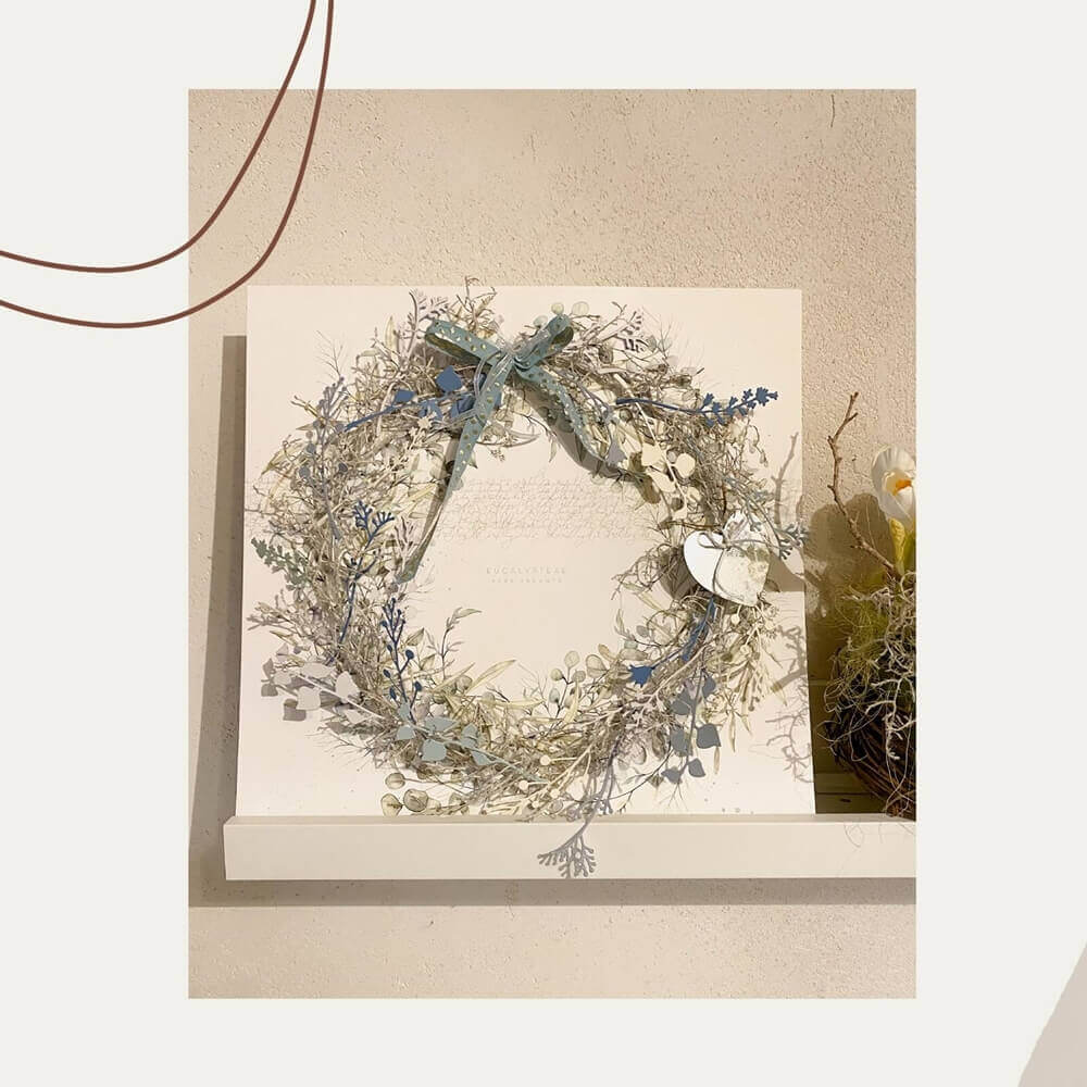 Die "Stanzschablone Fünf verschiedene Äste" von Stanzenshop.de, ideal zum Basteln oder Scrapbooking, setzt einen charmanten Akzent auf einem weißen Regal vor einer hellen Wand.