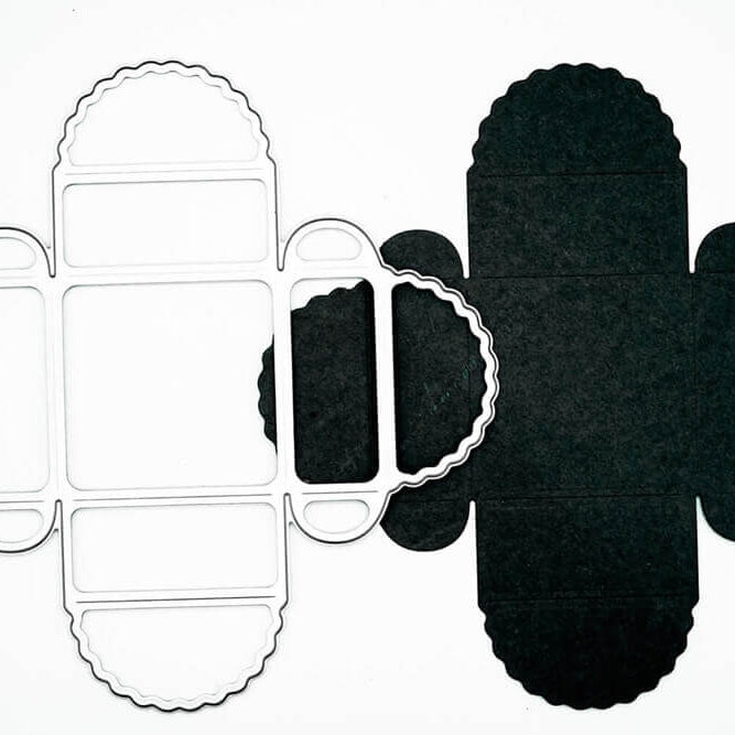 Das Stanzschablone Geschenkkästchen von Stanzenshop.de und sein schwarzer Papierausschnitt für eine Wellenkantenschachtel werden auf weißem Hintergrund gezeigt - ideal für Scrapbooking oder Basteln.