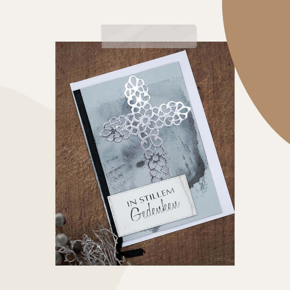 Eine Kondolenzkarte mit einem filigranen Metallic-Kreuz mit der Stanzschablone Großes Kreuz von Stanzenshop.de und dem Text "IN STILLEM GEDENKEN" auf grauem Grund - ideal für Kartenherstellung oder Basteln.