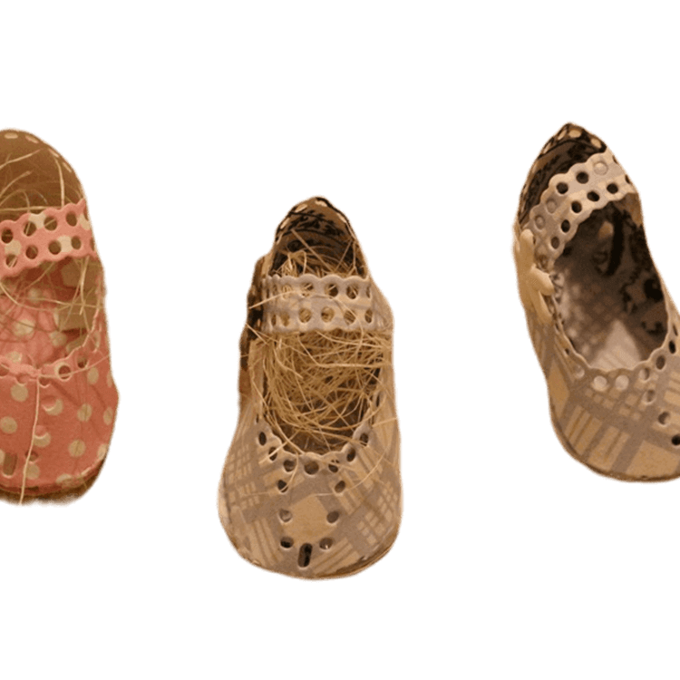 Drei handgefertigte, gewebte Babyschuhe mit perforierten Mustern sind auf weißem Hintergrund abgebildet - links rosa, in der Mitte strohgelb, rechts beige - eine ideale Inspiration für Ihre Projekte mit der Stanzschablone Kinderschuh für ein Baby von Stanzenshop.de.