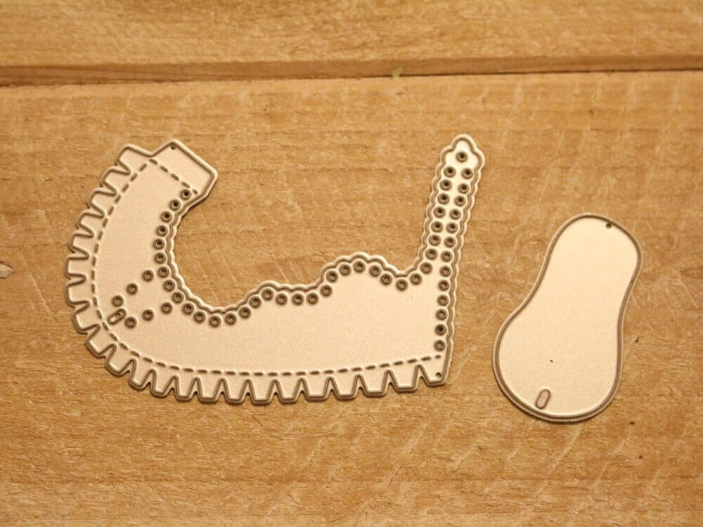 Die Stanzschablone Kinderschuh für ein Baby von Stanzenshop.de besteht aus einem Latzstempel mit Wellenschliff und einem kleinen Bohnenstempel, abgebildet auf einer Holzfläche - ideal für Scrapbooking.