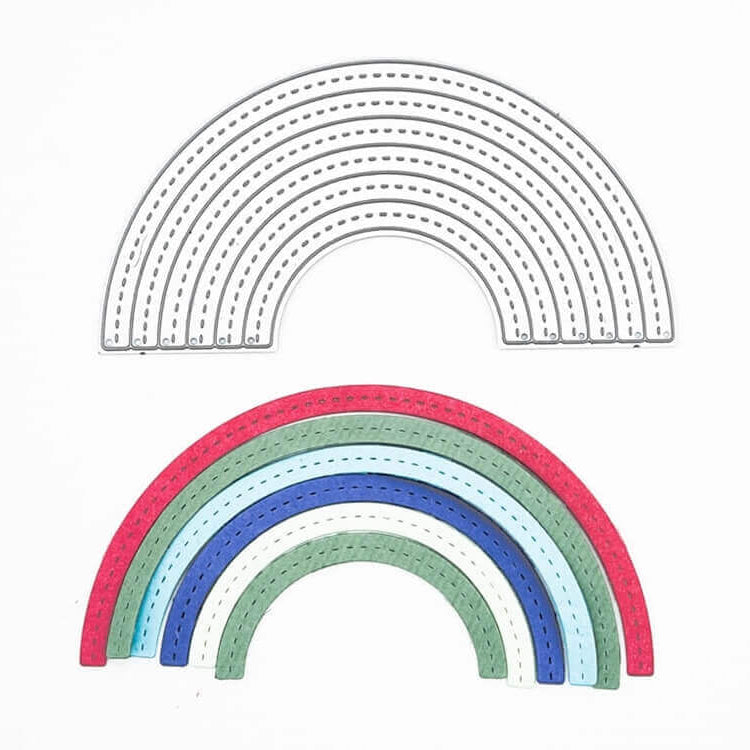 Die Stanzschablone Regenbogen von Stanzenshop.de liegt auf einem fertigen Bastelprojekt: ein bunter Regenbogen aus Papier auf weißem Hintergrund - kompatibel mit vielen Stanzmaschinen.