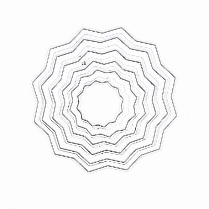 Eine Reihe konzentrischer, zickzackförmiger Ringe in einem kreisförmigen Muster auf Weiß - ideal für kreative Projekte mit der Stanzschablone: Rosette 6-teilig von Stanzenshop.de.