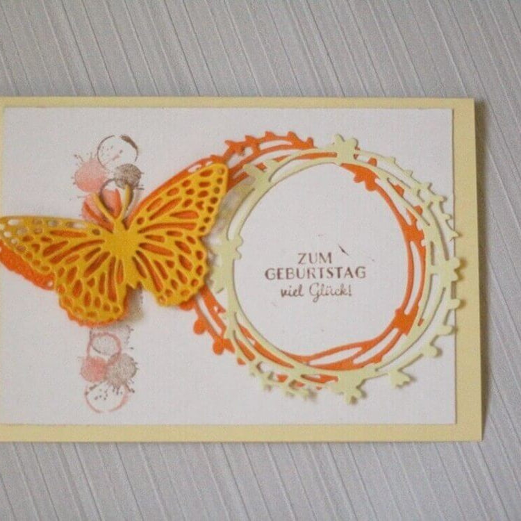 Handgefertigte Geburtstagskarte mit Stanzschablone Schmetterling mit extra Umriss von Stanzenshop.de, mit rundem Rahmen und "Zum Geburtstag viel Glück!" - ideal für Bastel-Fans auf hellem Hintergrund.