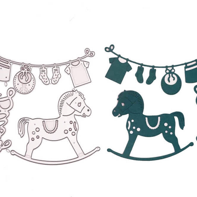 Das Stanzschablonen-Set Babyglück von Stanzenshop.de zeigt zwei Schaukelpferd-Konturen und "Baby" neben Kleidung auf einer Linie - eine in Silber, eine in Dunkelgrün - ideal für Bastelprojekte.