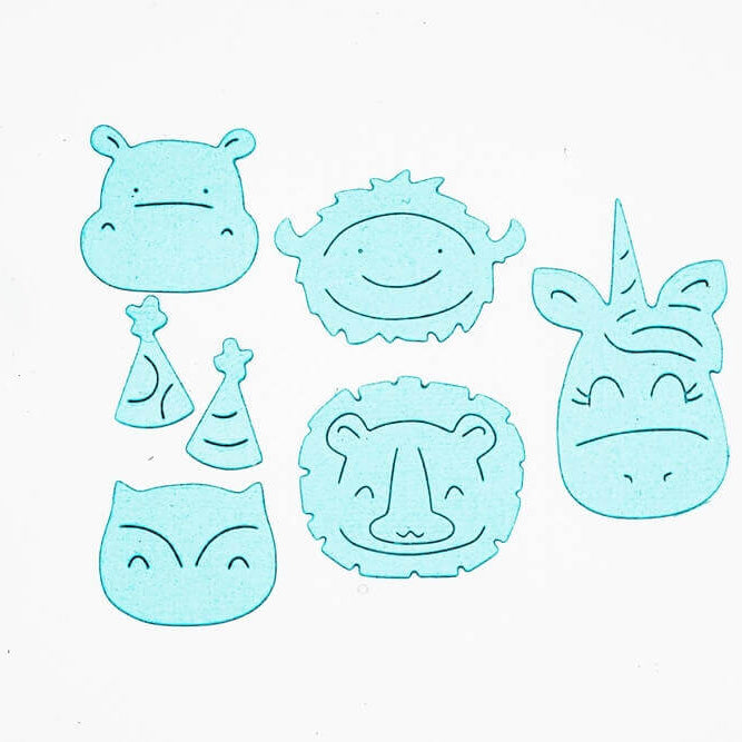 Sechs blaue Tierausschnitte - Hippo, Einhorn, Löwe, Eule, Bison - aus dem Stanzenshop.de Stanzschablone Set mit verschiedenen Tieren, ideal zum Basteln oder Scrapbooking, sind auf einem weißen Hintergrund mit zwei Partyhüten angeordnet.