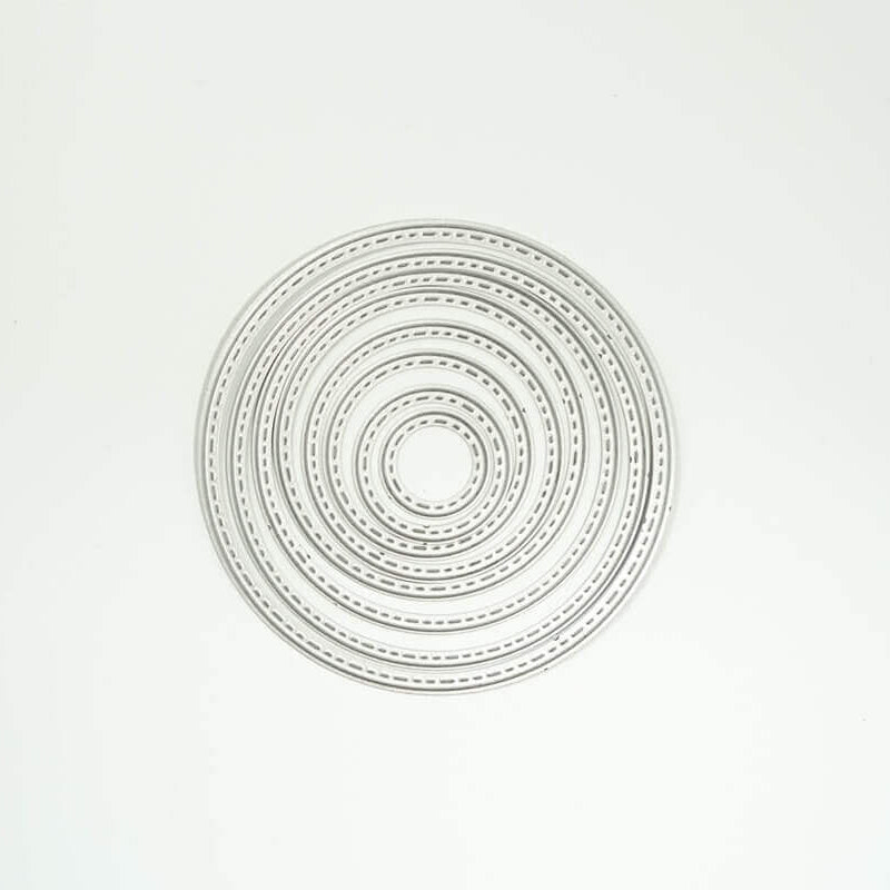 Die "Stanzschablone: Sieben Kreise mit gestricktem Rahmen" von Stanzenshop.de zeigt konzentrische Metallringe mit dekorativen Rändern, ideal für Scrapbooking und Basteln, in einem kreisförmigen Muster auf einem schlichten weißen Hintergrund.