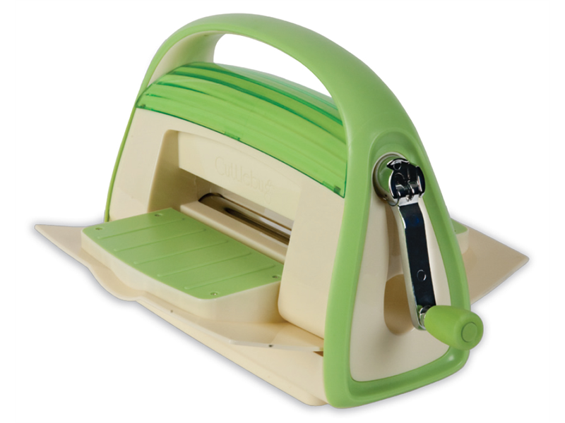 Eine grüne und cremefarbene manuelle Stanzmaschine mit einem Griff und einer seitlichen Kurbel, die zum Basteln und Schneiden verschiedener Formen aus Papier oder Stoff gedacht ist.