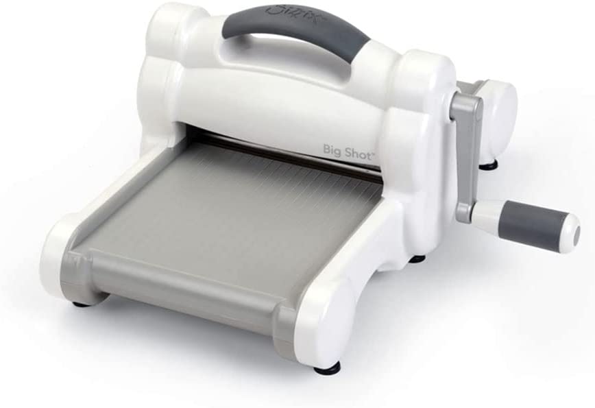 Eine weiß-graue manuelle Stanzmaschine mit Handgriff und Kurbel mit der Bezeichnung "Big Shot", die zum Basteln und Schneiden von Materialien bestimmt ist.
