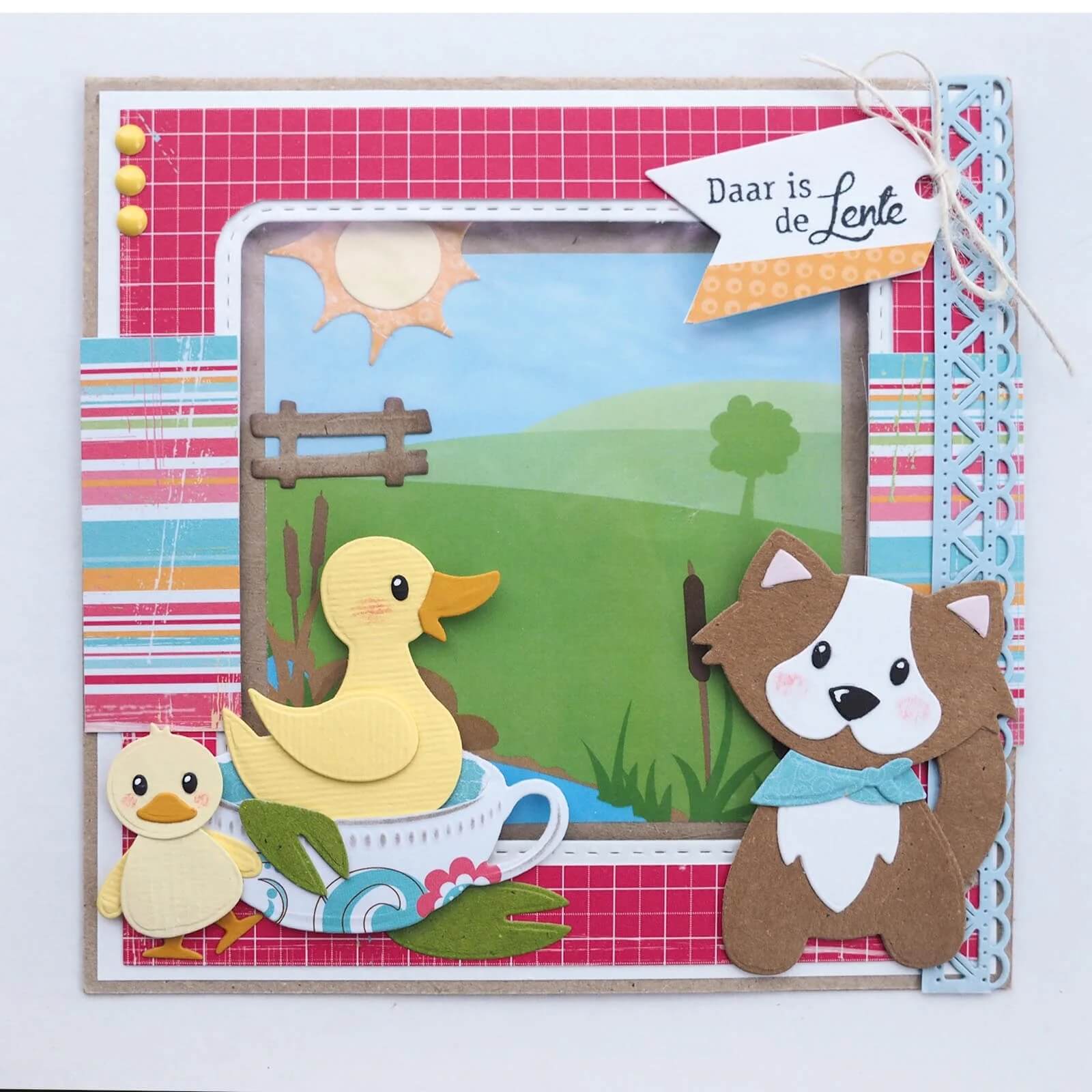 Handgefertigte Karte mit Marianne Design Collectables Präge- und Stanzschablone Eline's Entenfamilie, mit Papierausschnitten von Enten und einem Hund im Gras, holländischem Zeichen "Daar is de Lente" und bunten Rändern - ideal für Scrapbooking.