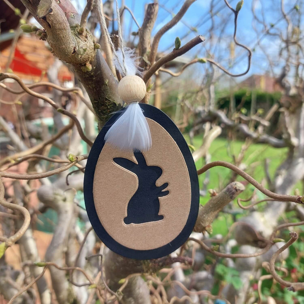 Eine Stanzschablone Ostereier mit Hase, Ostern, Osterfest, Frühling, Tiere, die an einem Baum in einem Garten hängt. (Marke: Stanzenshop.de)
