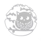 Die Stanzschablone Eule auf einem Ast von Stanzenshop.de ist eine silberne Metallstanze, die eine Eule auf einem Ast mit Blättern und einem kreisförmigen Rand zeigt - ideal für Bastelprojekte.