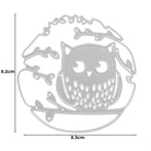 Die Stanzschablone Eule auf einem Ast von Stanzenshop.de ist ein silberner Metallstempel mit Blattdetails, ideal für Bastelprojekte. Größe: 8,2 x 8,3 cm.