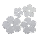Vier silberne Metallstempel in Blütenform von Stanzenshop.de, genannt "Stanzschablone: Blume aus mehreren Einzelteilen", in verschiedenen Größen mit fünf Blütenblättern und Mittelloch - ideal für Scrapbooking oder kreative Projekte als Stanzschablone Blumen.