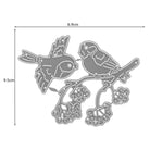 Die Stanzschablone Zwei Vögel mit einem Ast von Stanzenshop.de ist eine Metallstanze mit zwei Vögeln auf einem Beerenzweig, ideal für Scrapbooking oder Basteln. Größe: 9,5 cm x 6,9 cm.