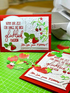 Zwei handgefertigte Grußkarten mit Erdbeeren und Blättern, hergestellt mit der "Stanzschablone Erdbeeren" von Stanzenshop.de, mit deutschem Text auf einer grünen Schneidematte mit Bastelwerkzeug im Hintergrund.