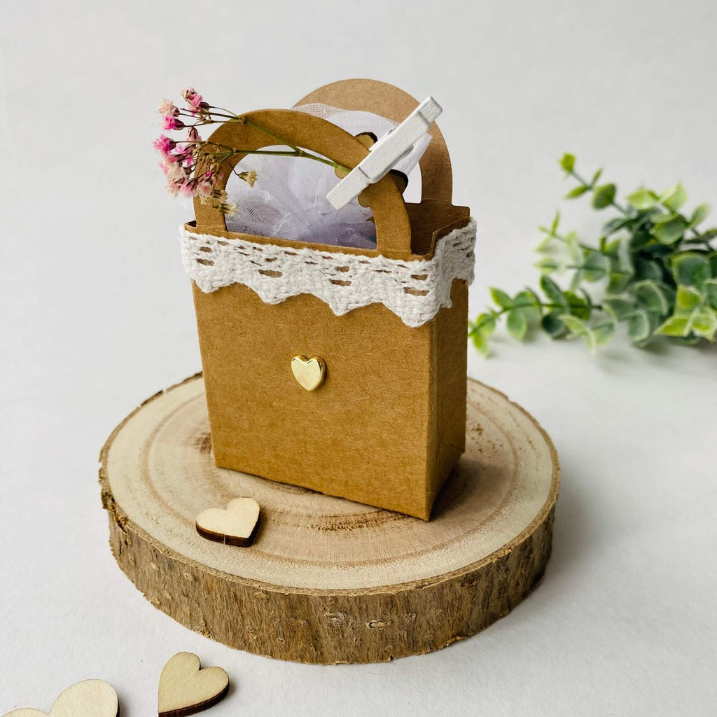 Eine handgefertigte Geschenktüte aus Papier mit Spitzendetails und dekorativen Stanzblumen auf einer Holzscheibe von Stanzschablone Kleine Tasche von Stanzenshop.de.