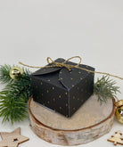 Die "Stanzschablone Quadratische Schachtel mit Verzierungen" von Stanzenshop.de zaubert eine festliche, schwarze Box mit Goldakzenten - ideal zum Basteln oder für kreative Geschenkideen in der Weihnachtszeit.