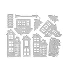 Die Stanzschablone "Fünf verschiedene Häuser mit Zubehör" von Stanzenshop.de zeigt verschiedene silberne Metallstanzformen - Häuser, Fenster, Bäume, einen Zaun, einen Laternenpfahl und festliche Akzente - auf weißem Hintergrund.