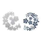 Abgebildet sind zwei kreisrunde Blumenmuster: eine silberne Stanzenshop.de Stanzschablone: Blumenrand-Stanzung und ein dunkelblauer Papierausschnitt mit passenden Blumen- und Blattmustern - ideal für Scrapbooking oder Bastelprojekte.