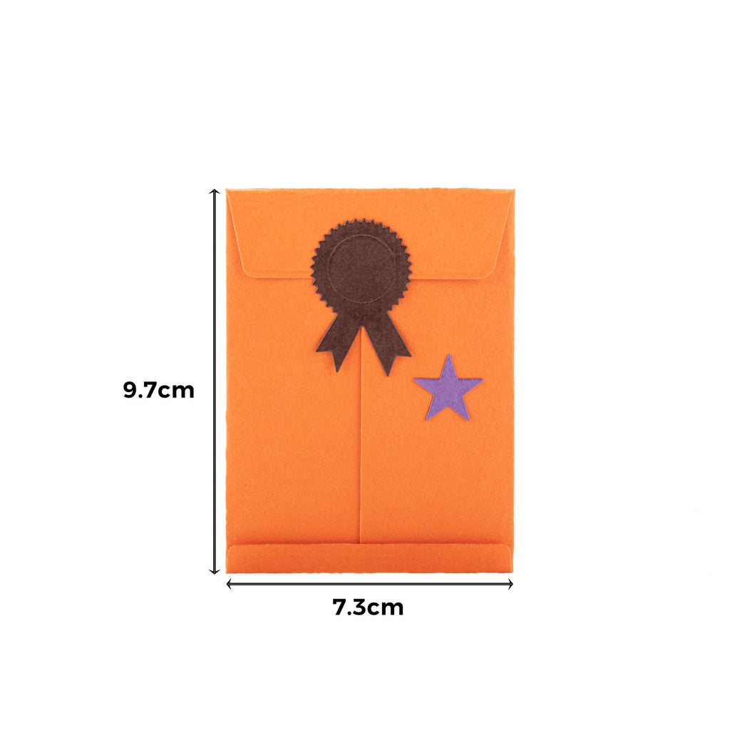 Eine orangefarbene Stanzschablone: Umschlag mit Zubehör, verziert mit einem sternförmigen Stanzer von Stanzenshop.de.
