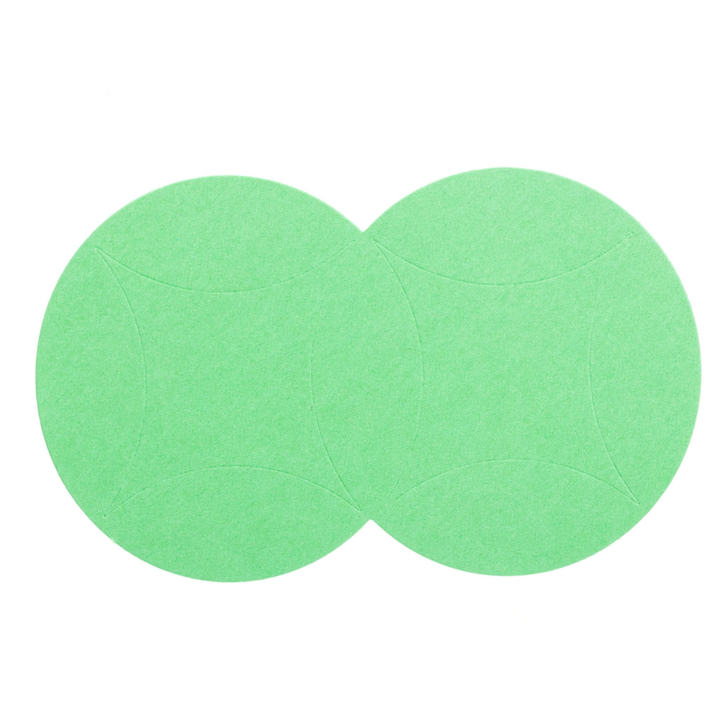 Zwei überlappende grüne Kreise aus Papier auf weißem Hintergrund ausgeschnitten mit einer Stanzenschablone: Kissenschachtel von Stanzenshop.de.