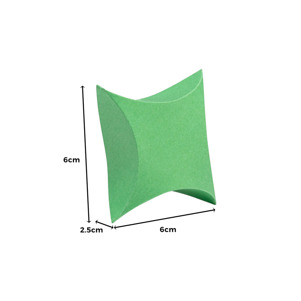 Ein grünes geometrisches Objekt mit einer hohlen Mitte, das einer Stanzschablone ähnelt: Kissenschachtel von Stanzenshop.de, misst 6 cm in der Höhe, 6 cm in der Breite und 2,5 cm in der Tiefe.