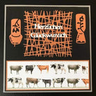Eine handgefertigte Karte mit orangefarbenen Ausschneidemotiven aus dem Stanzschablone Gittermuster von Stanzenshop.de, mit "Herzlichen Glückwunsch" und zwei Reihen Kuh-Illustrationen - ideal für Karten basteln oder Scrapbooking-Projekte.