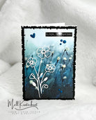 Eine handgefertigte Grußkarte mit blauem Blumenhintergrund, weißen Blumenkonturen aus Stanzschablone Blume mit drei Blüten von Stanzenshop.de, blauen Herzakzenten und "Super liebe Grüße" - ideal zum kreativen Basteln.