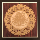 Ein rundes Papierdeckchen mit einem Ausschnitt von zwei Glocken und einer Schleife, hergestellt mit der Stanzenshop.de Stanzschablone: Zwei Weihnachtsglocken, ausgestellt auf einer Holzfläche.