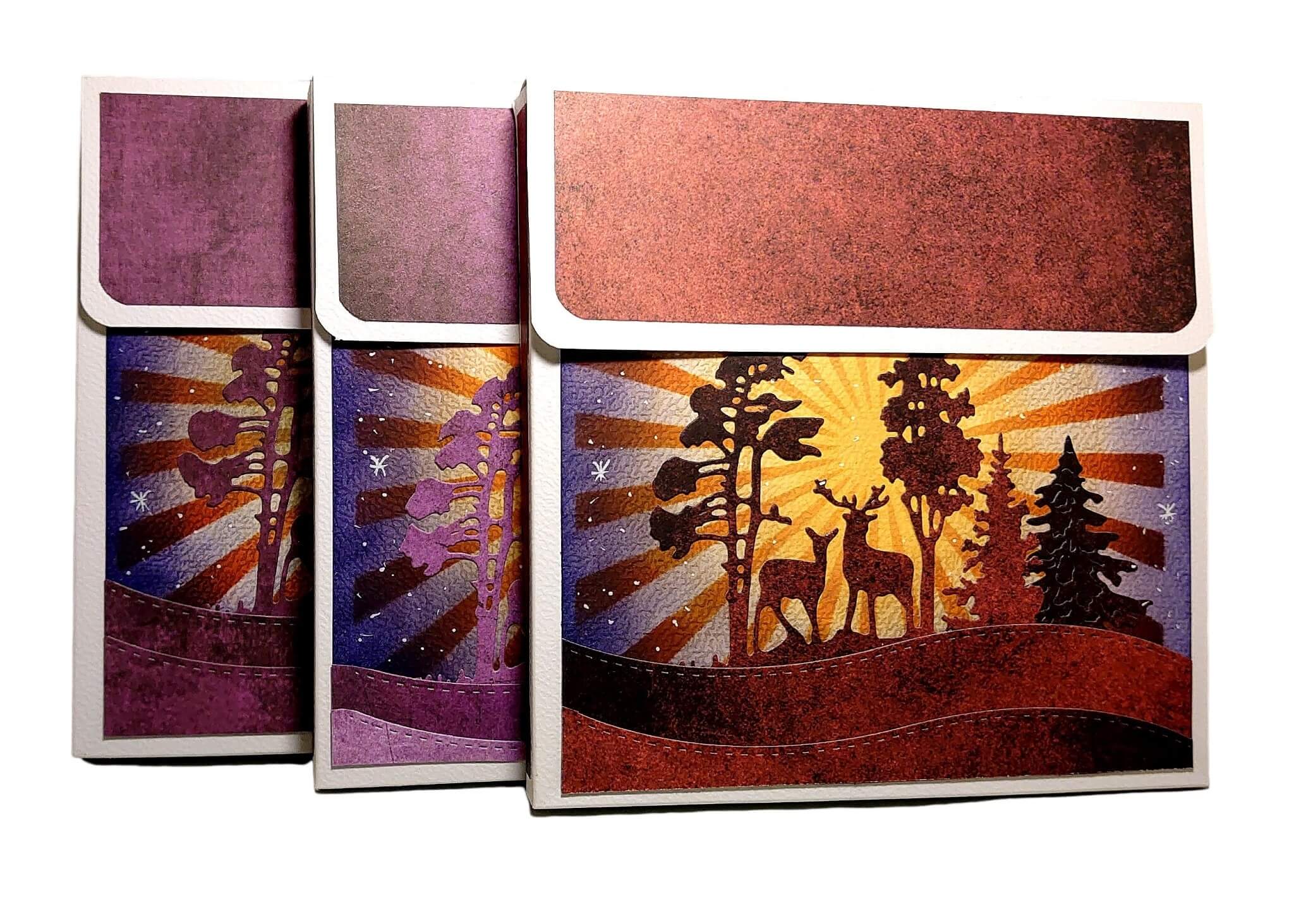 Drei rechteckige Dosen mit Deckel zeigen eine lebendige Waldszene mit Reh und Sonnenuntergang, ideal zum Basteln von Karten oder zur Ergänzung Ihrer Stanzenshop.de Stanzschablone: Winterlandschaft im Halbkreis gestaltet.