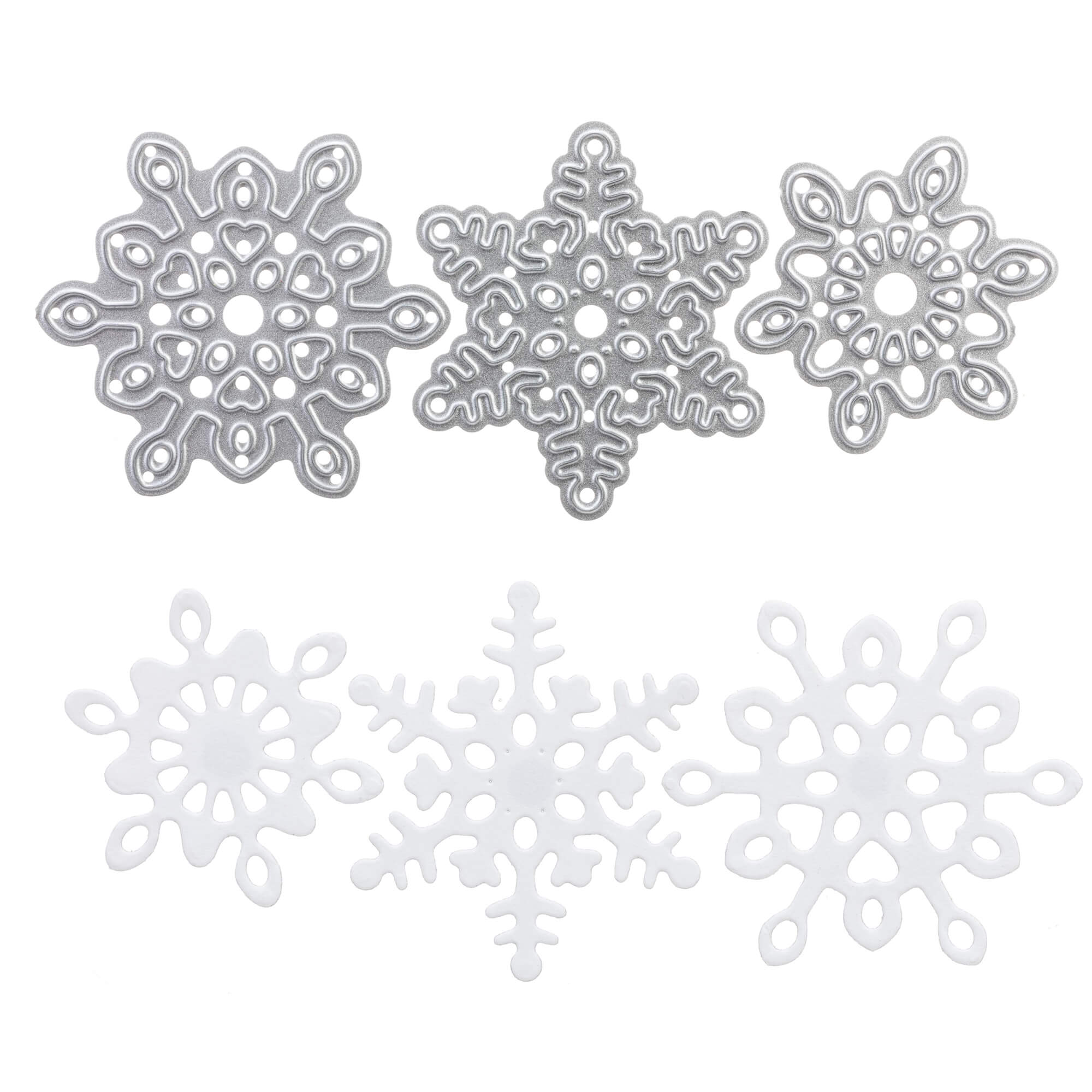 Drei detailreiche silberne Schneeflocken-Ornamente und drei passende weiße ausgeschnittene Schneeflocken, gefertigt mit der Stanzschablone: Drei kleine Schneekristalle von Stanzenshop.de sind auf weißem Untergrund angeordnet - ideal zum Basteln oder für winterliche Dekorationen.