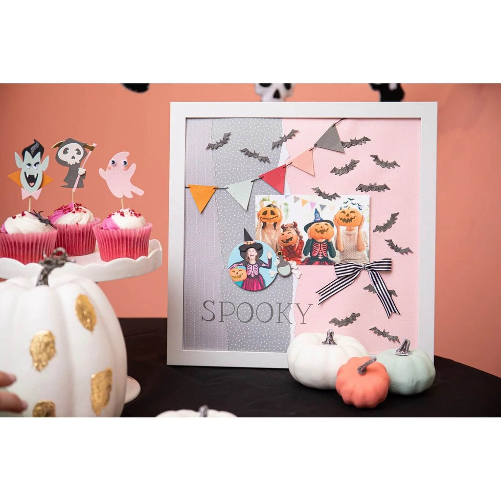 Ein gruseliger Fotorahmen, geschmückt mit Halloween-Dekorationen und Cupcakes, auf dem die Sizzix • Thinlits Die Set Spooky Icons prominent abgebildet sind.